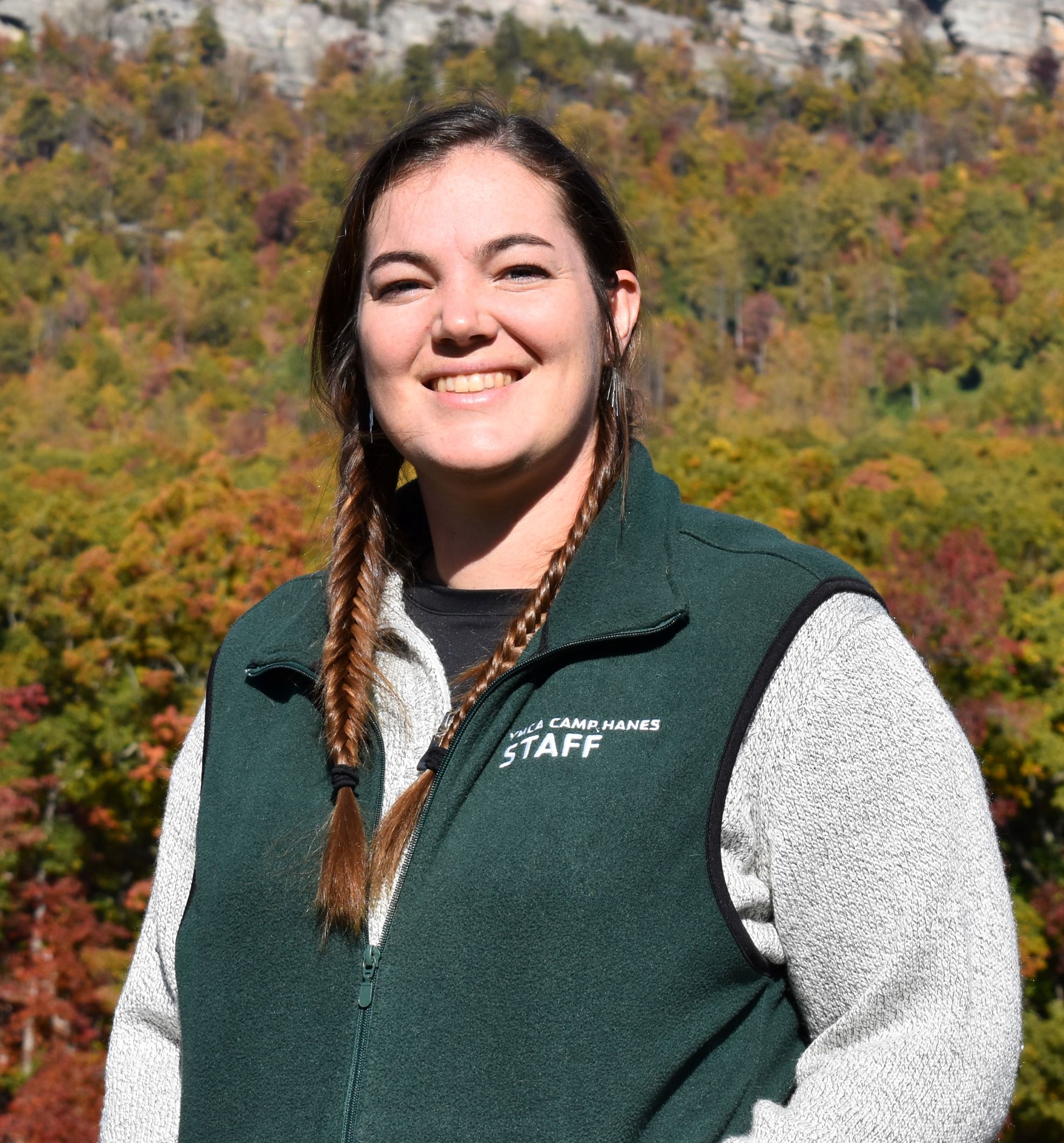 Woman in front of mountain with green vest