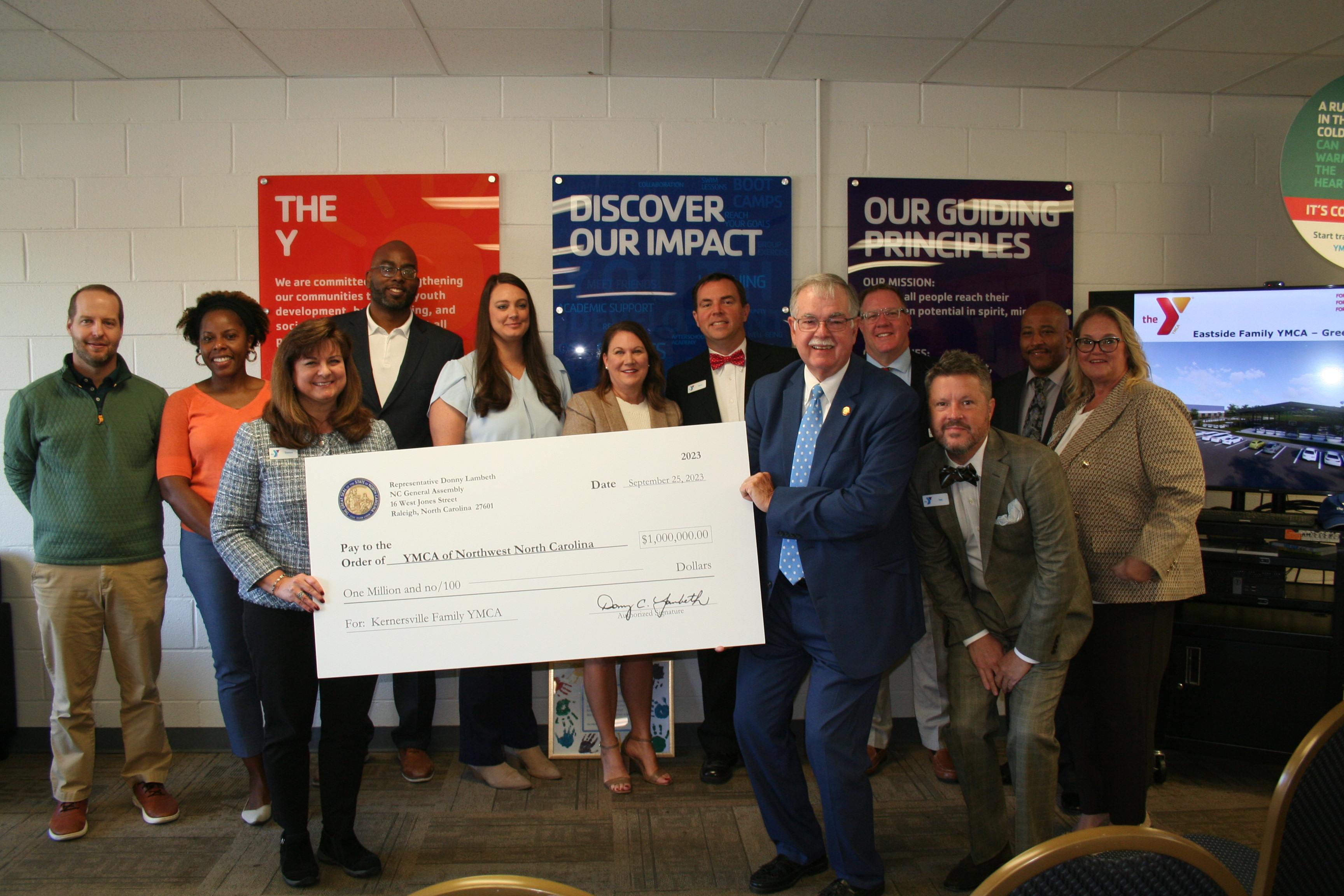 Group of people holding large check