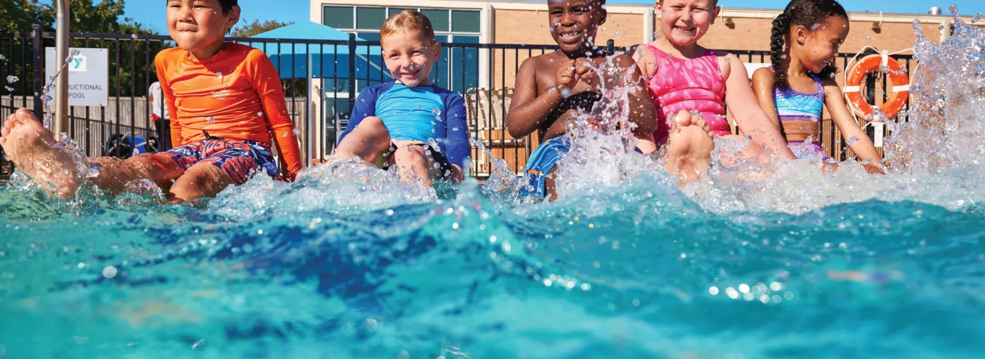 Kids on the side of the outdoor pool